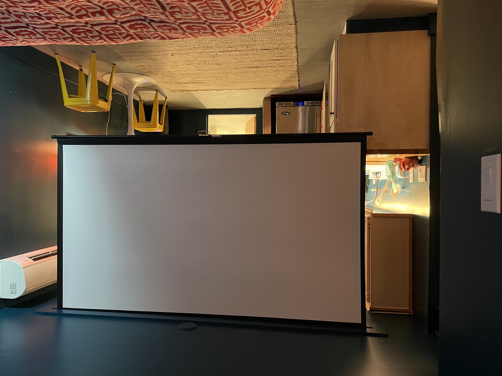 Pull-down projection screen deployed in the living area