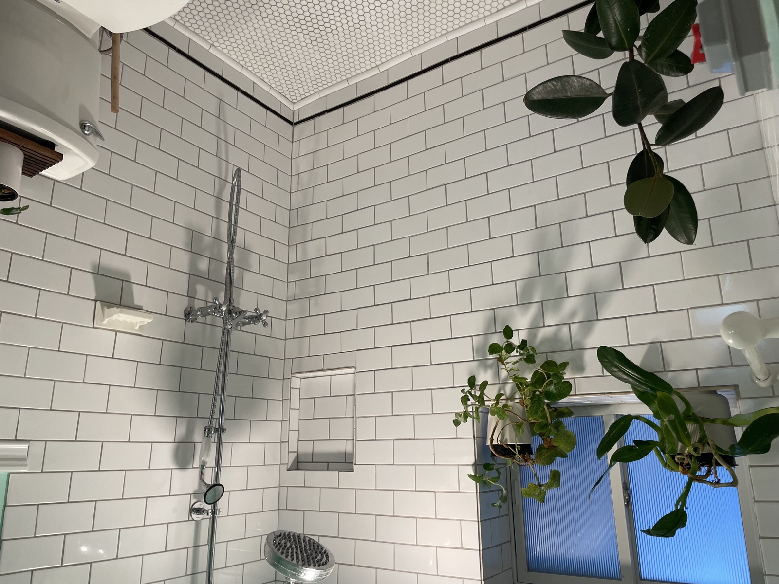 Shower with white subway tile and rain head from second angle